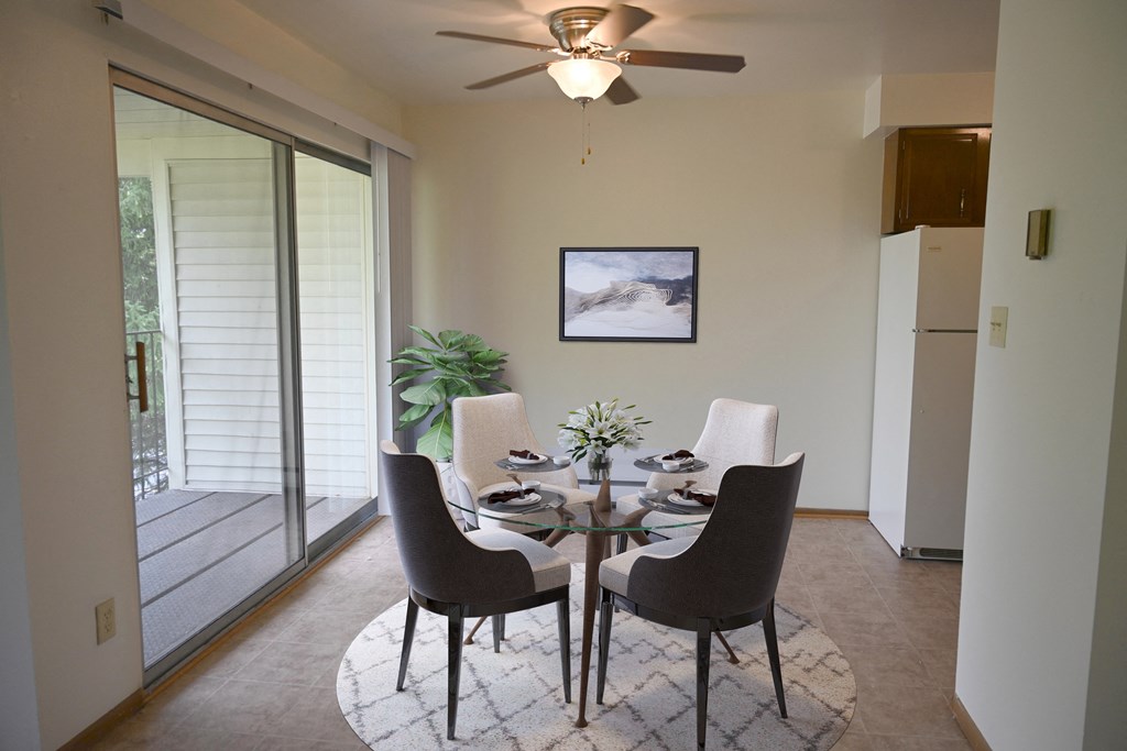 a dining room with a table and chairs and a ceiling fan
