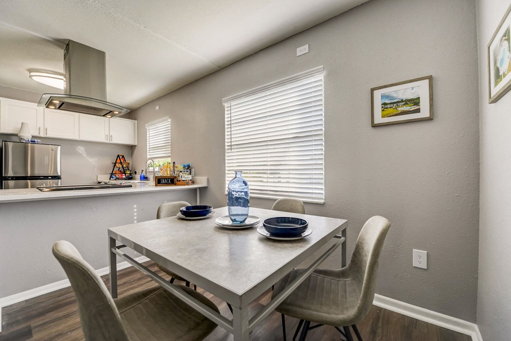 a dining area with a table and chairs and a kitchen