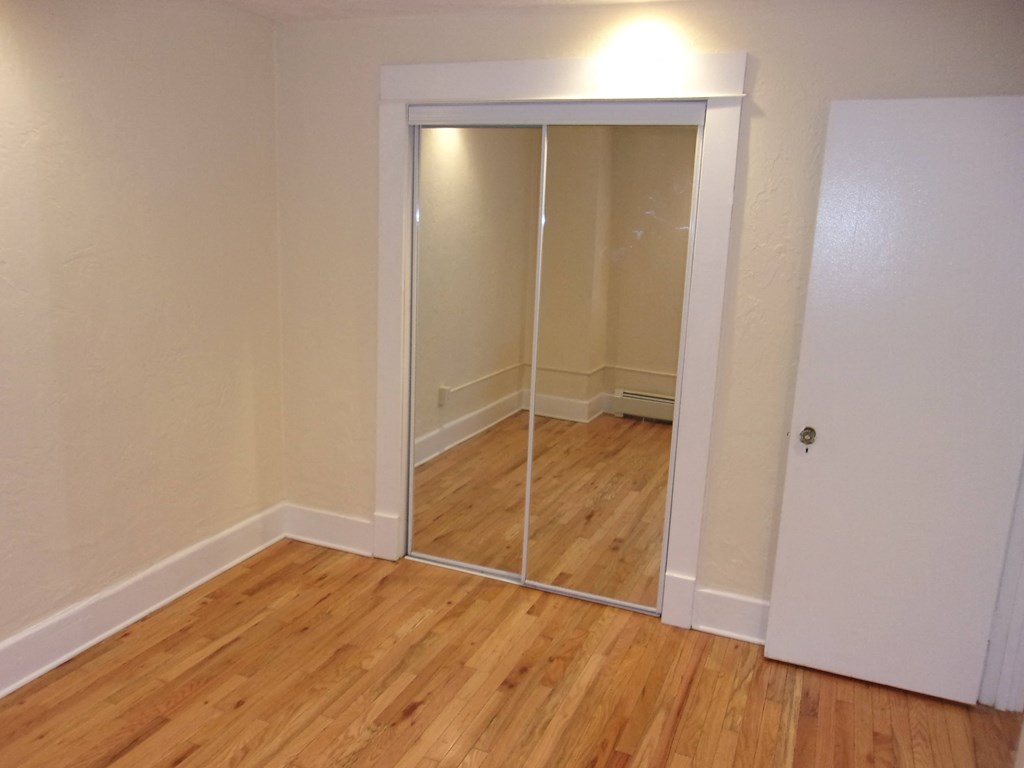 a bedroom with a mirrored closet door