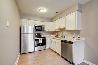 Renovated Apartment Home Kitchen at Fernwood Grove Apartments at 4900 MacDill Ave in Tampa, Florida