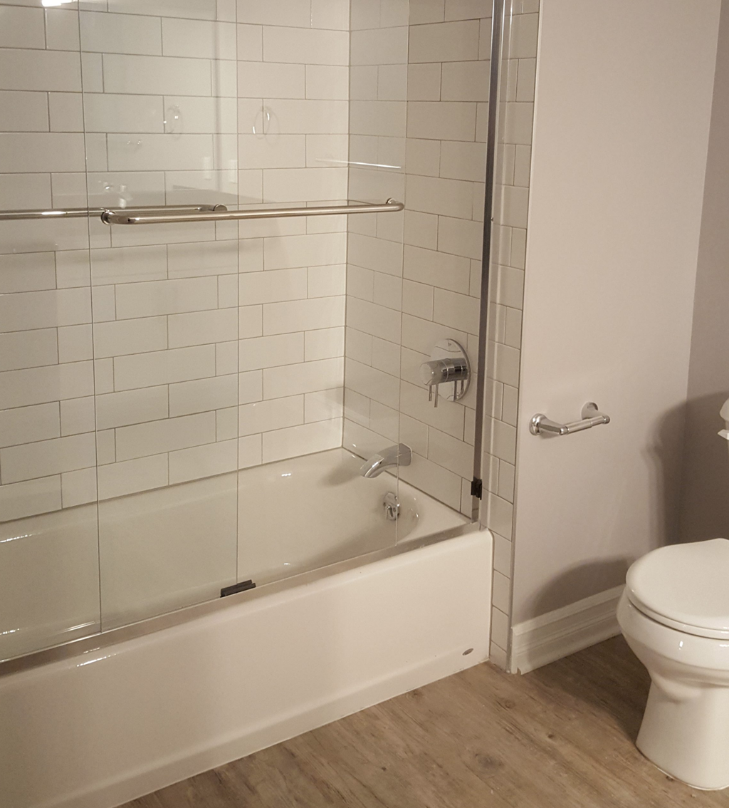 a white bathroom with a shower and a toilet