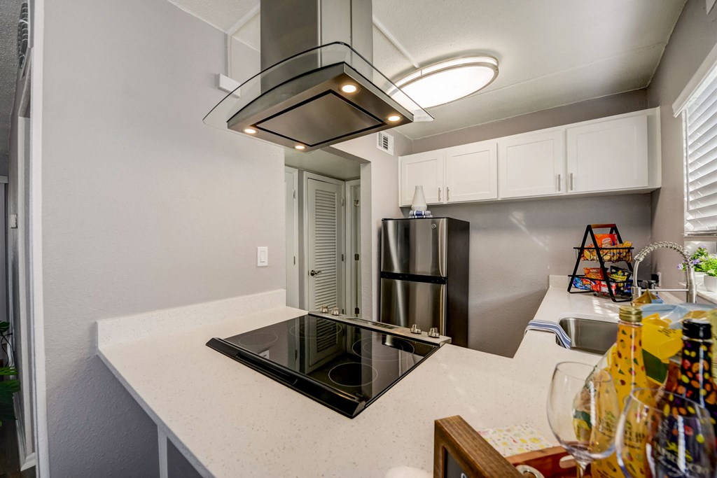 a kitchen with a island and a stove and a refrigerator