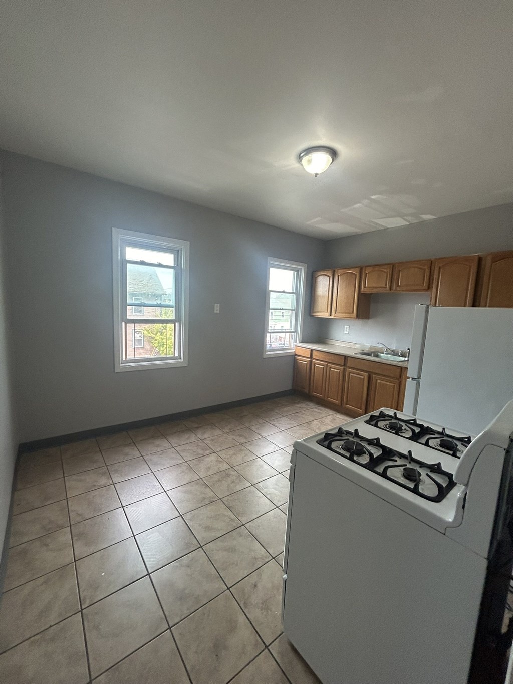 an empty kitchen with a stove and a refrigerator