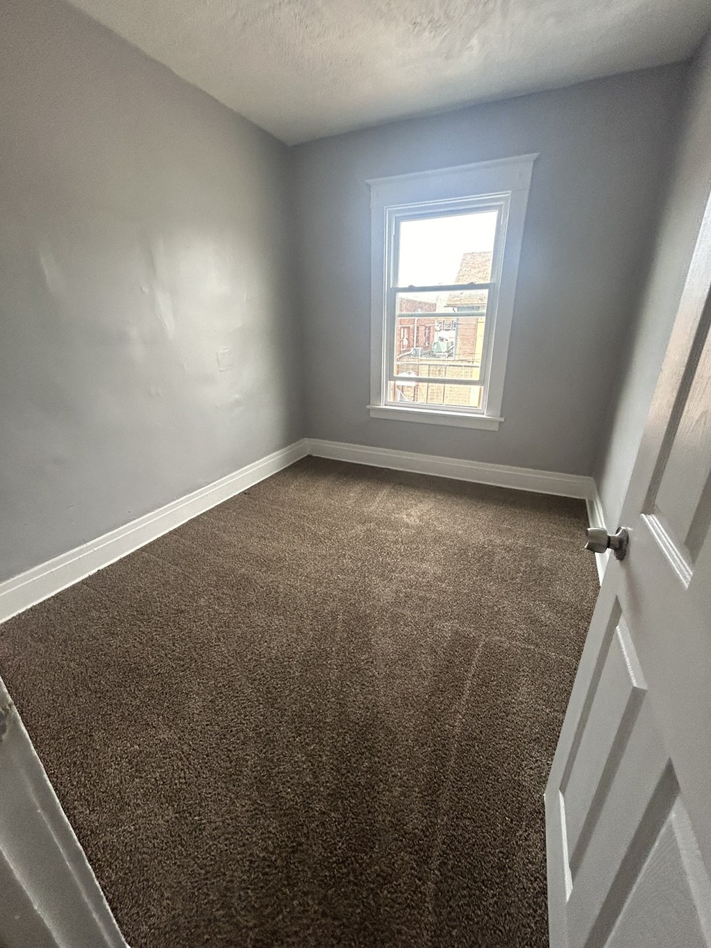 an empty room with a carpeted floor and a window