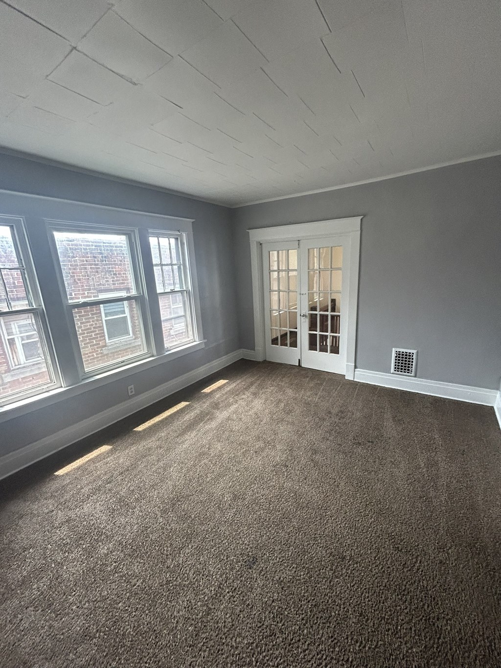 the living room of a new home with gray walls and carpet