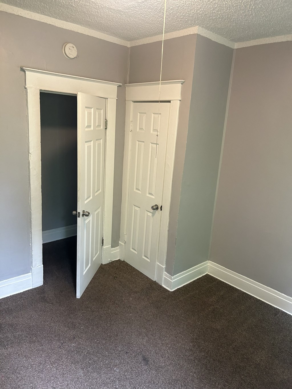 a bedroom with two doors and a closet