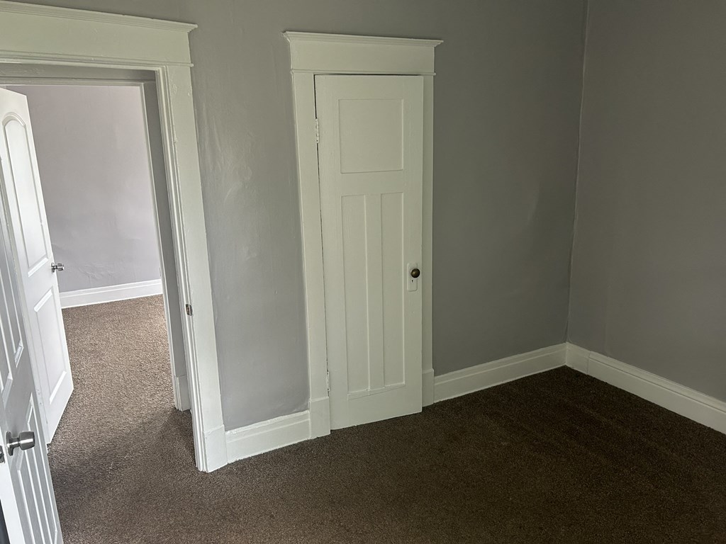 a bedroom with a white door and a closet