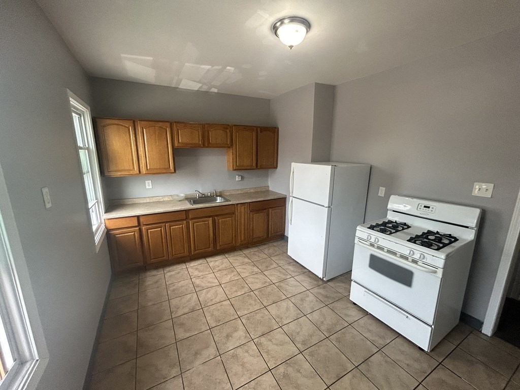 an empty kitchen with a stove refrigerator and sink