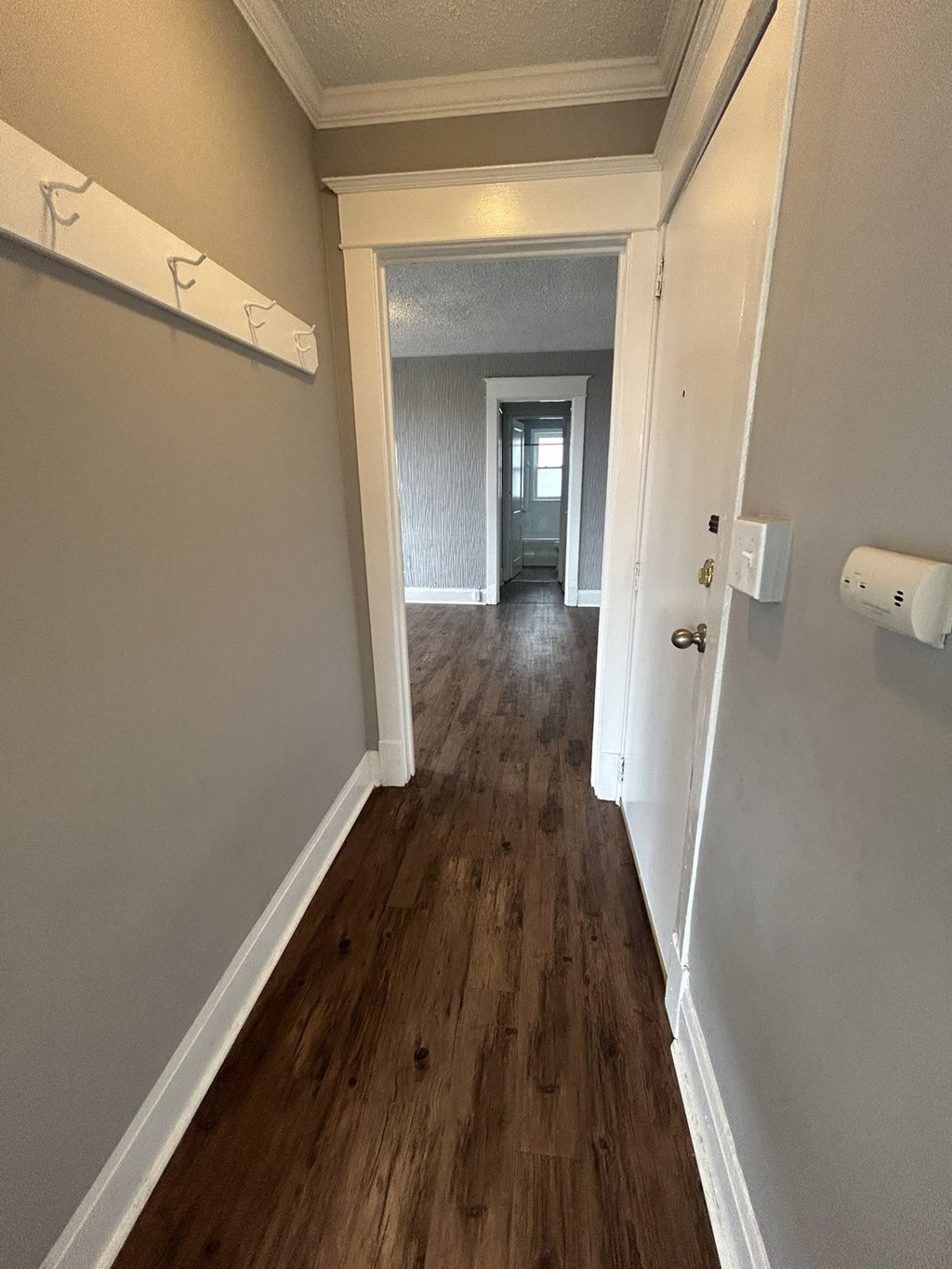a hallway with hardwood floors and a door to a room with a hall way