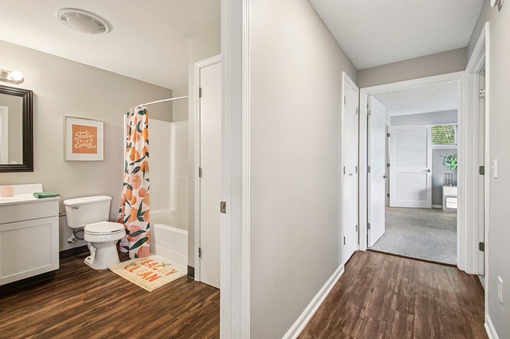 A bathroom with a toilet, sink, and a shower curtain with a floral pattern.