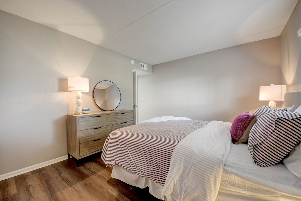 a bedroom with a bed and a dresser with a mirror