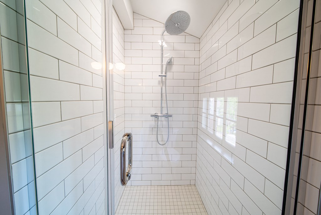 Shower detail shot showing glass door and overhead shower