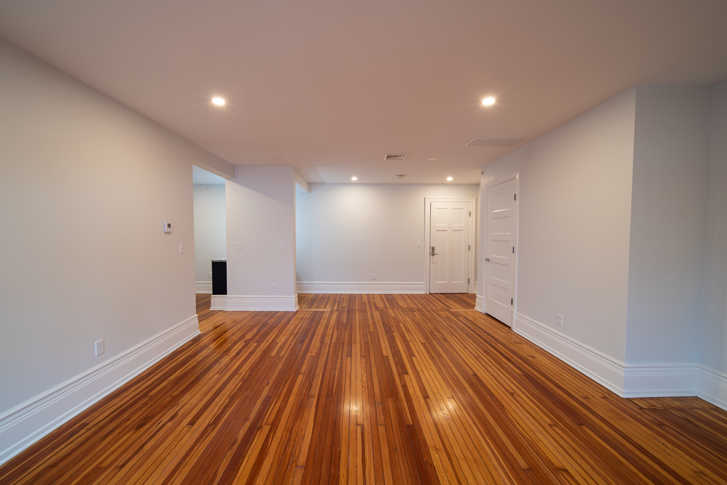 a living room with wooden floors and white walls