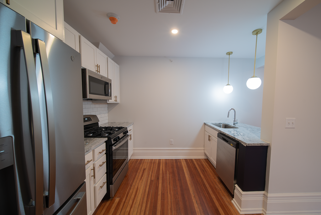 a kitchen with stainless steel appliances and wooden floors