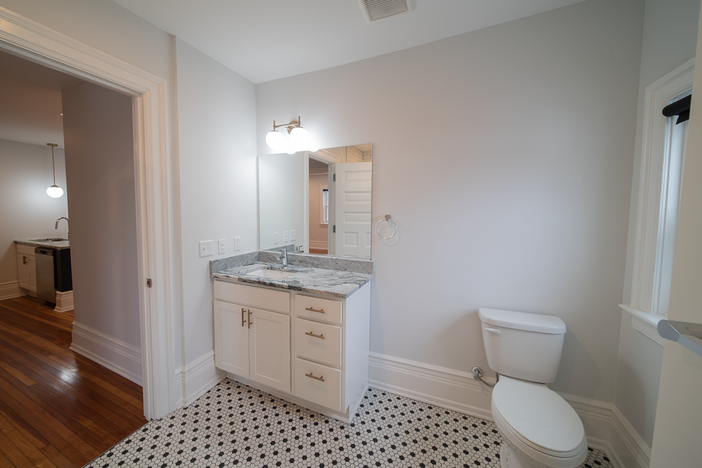 a bathroom with a toilet and a sink and a mirror