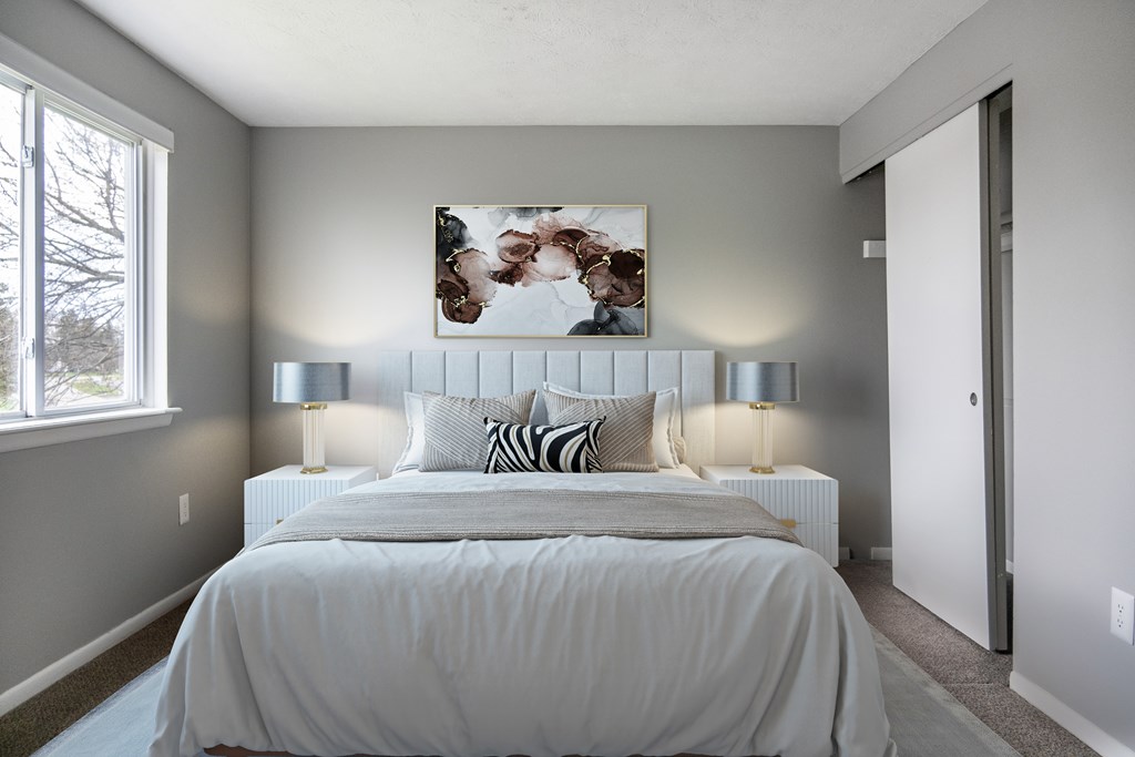 A bedroom with a large bed and a painting above it.