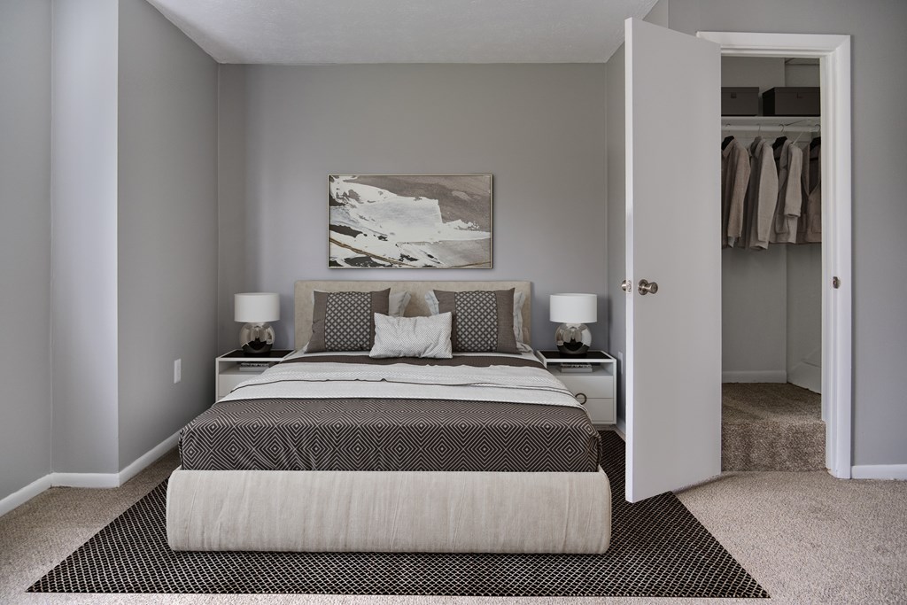 A bedroom with a large bed and a painting on the wall.
