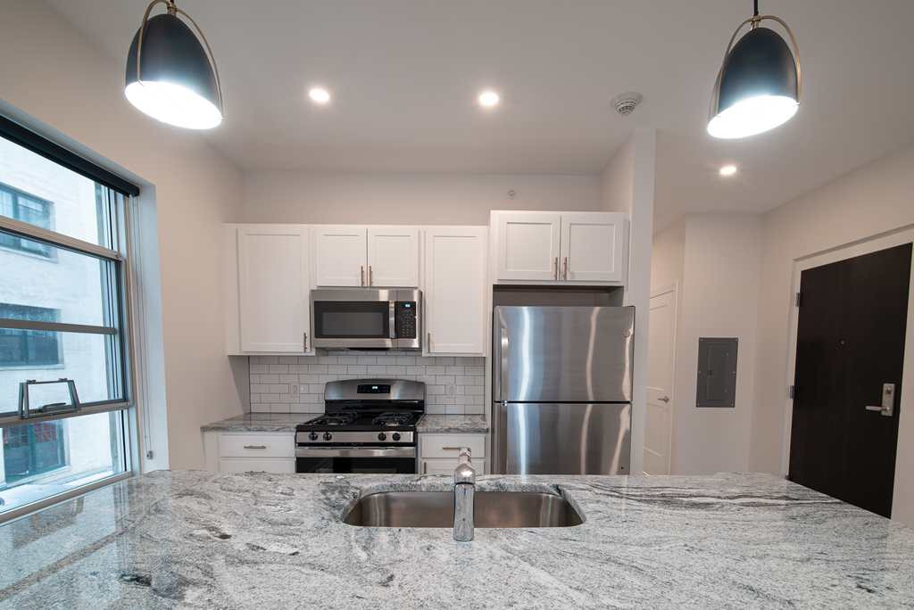 a kitchen with a granite counter top and a stainless steel refrigerator