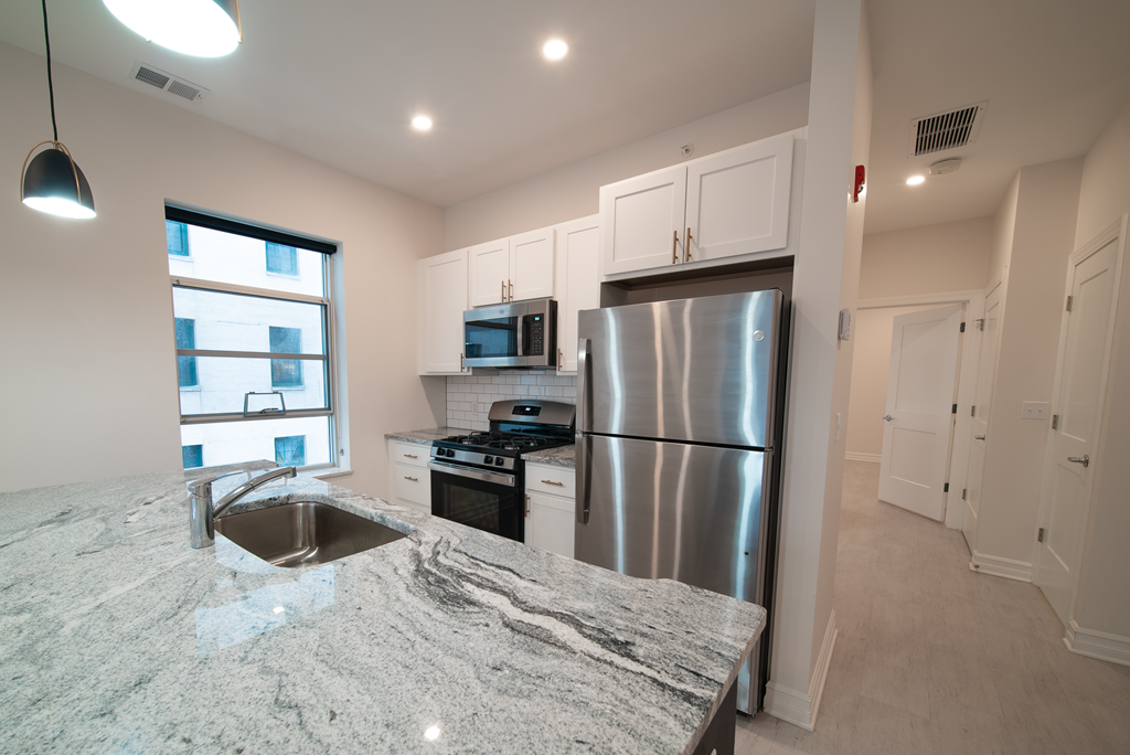 a kitchen with a granite counter top and stainless steel refrigerator