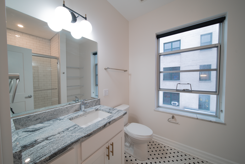 a bathroom with a sink toilet and a mirror