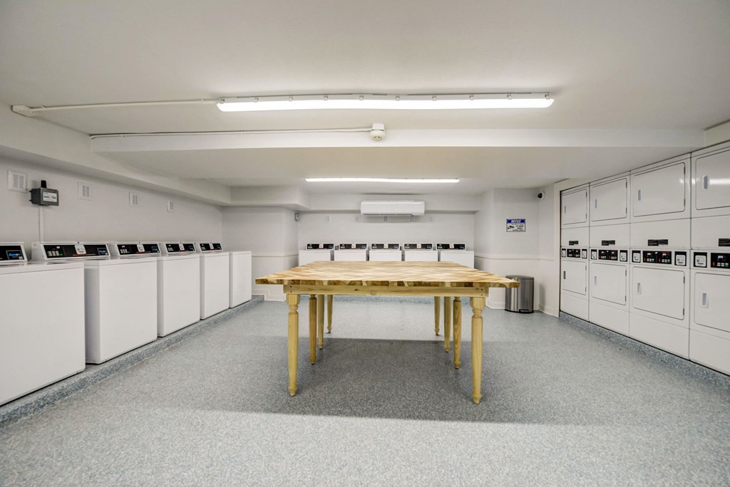 a large room with white cabinets and a table in the middle
