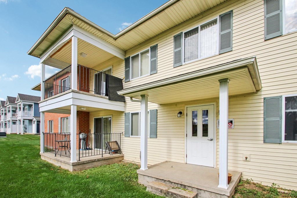 A two-story house with a white door and a balcony.