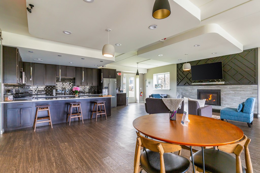 A modern kitchen with a wooden table and chairs.