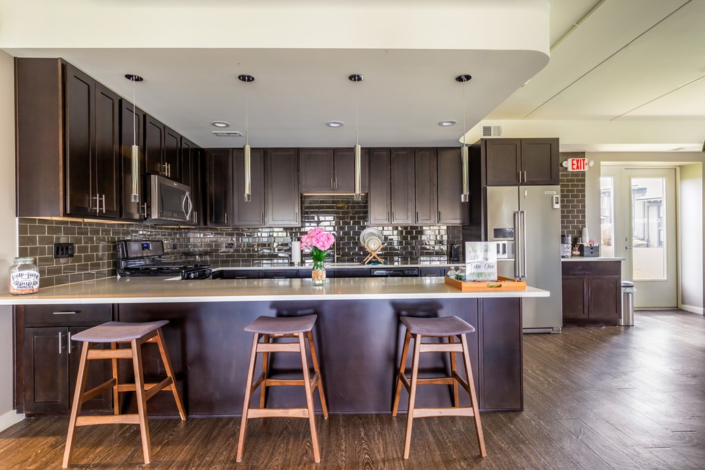 A kitchen with a bar area and two stools.