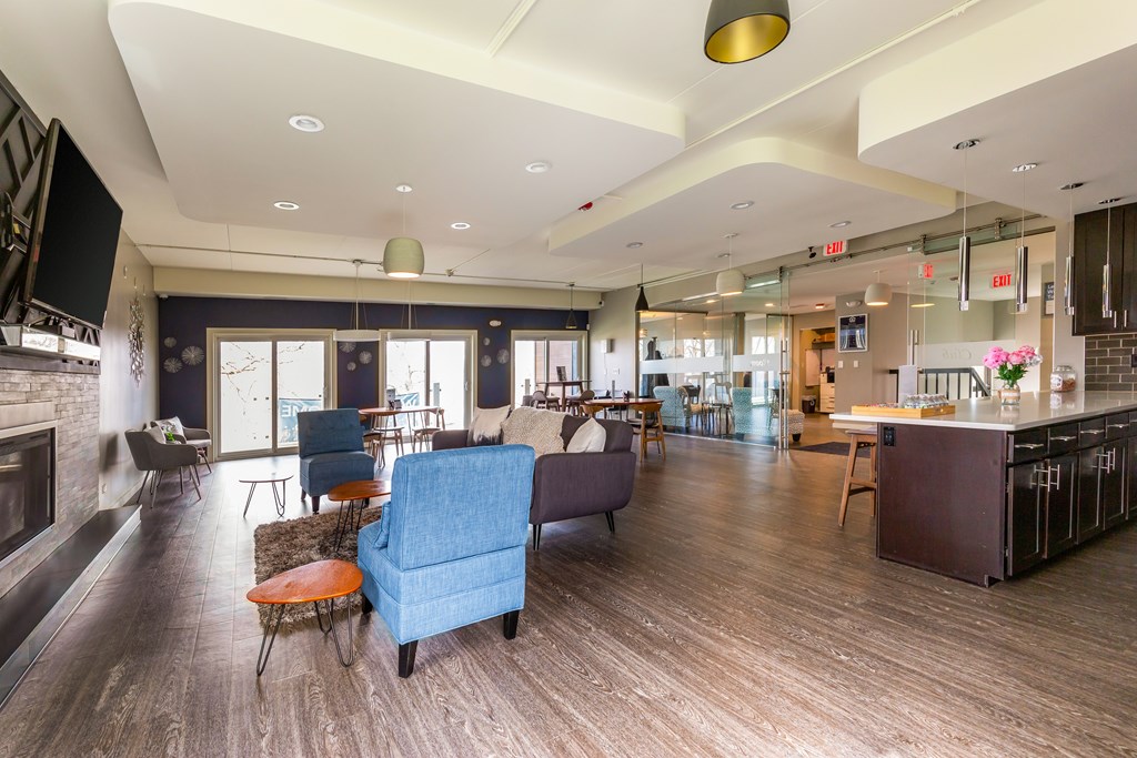 A modern living room with a fireplace and a kitchen area.