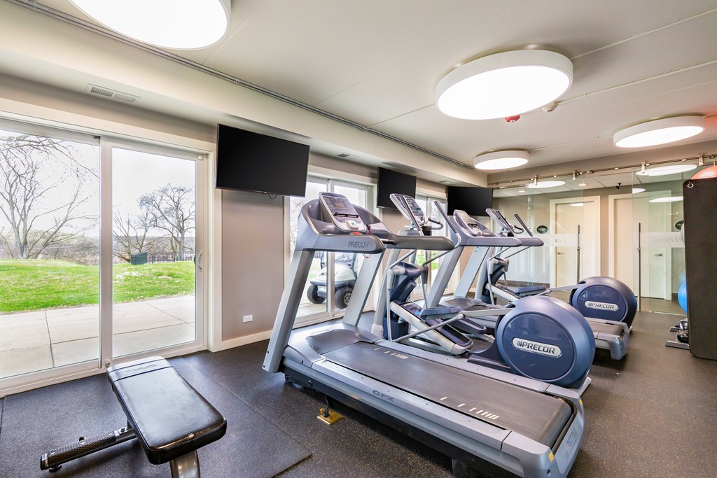 A gym with treadmills and a television.