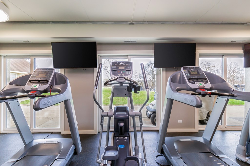 A gym with treadmills and elliptical machines.