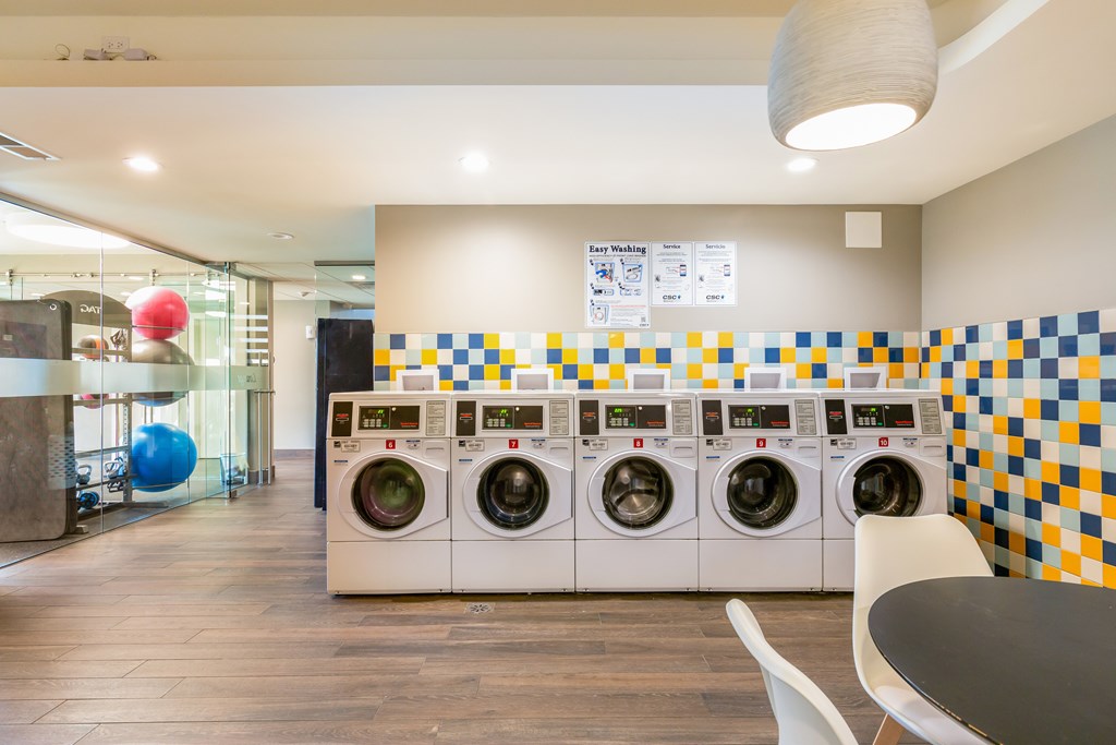 A laundromat with a row of washers and dryers.