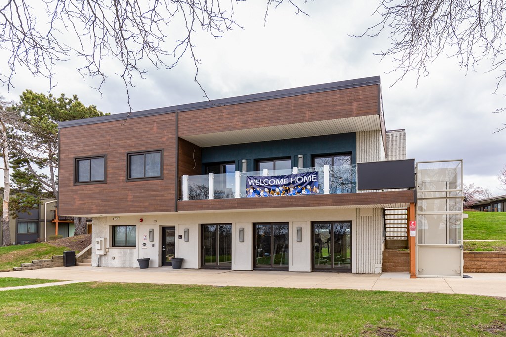 A modern house with a large glass window and a sign that says "Welcome Home".