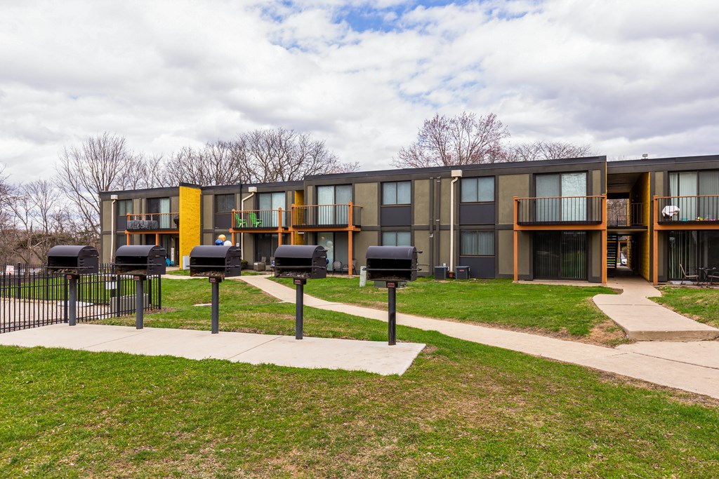 A modern building with a yellow and grey exterior and a black fence in front.