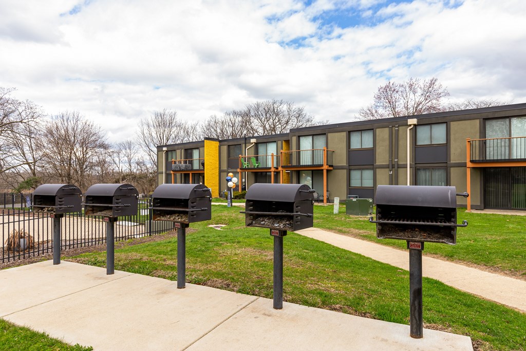 A row of black mailboxes in front of a building.