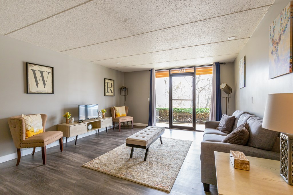 A living room with a grey couch and a white sofa.