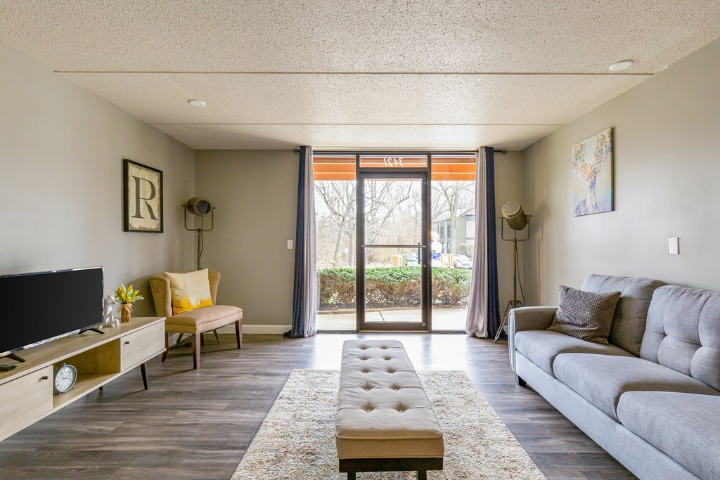 A living room with a grey couch, a wooden coffee table, and a flat screen TV.
