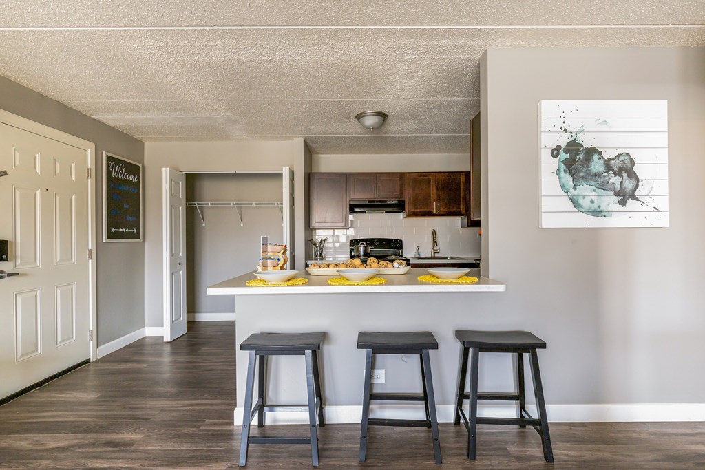 A kitchen with a bar stool in front of a counter.