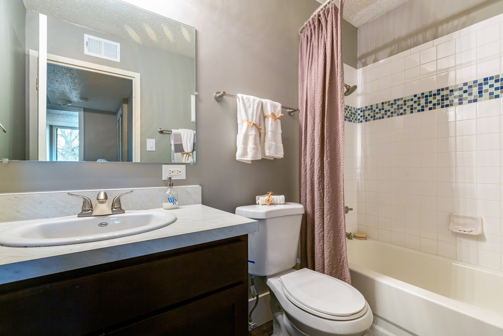 A bathroom with a white sink and a white toilet.