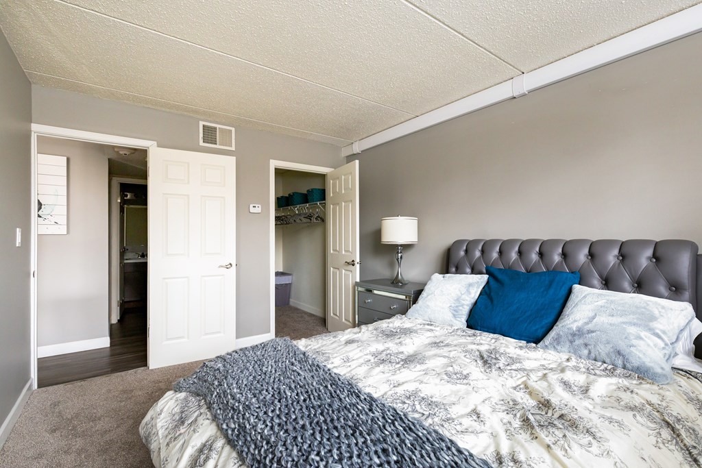 A bedroom with a bed, nightstand, and a lamp.