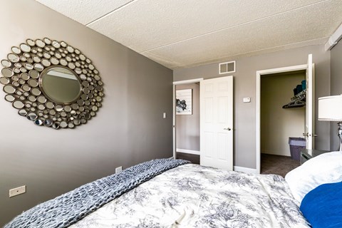 A bedroom with a bed and a mirror on the wall.