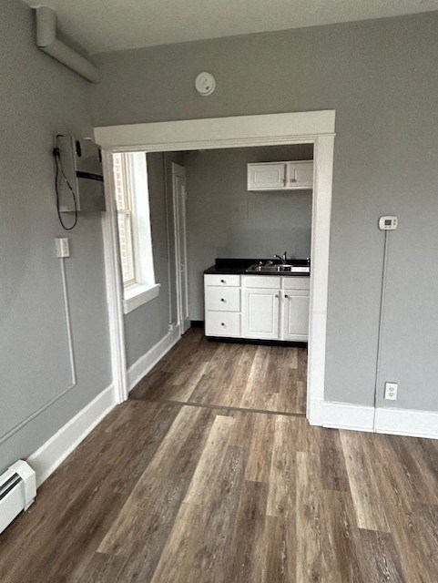 an empty room with a kitchen and a door way