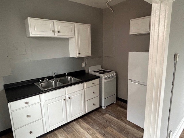 a kitchen with white cabinets and a stove and a refrigerator