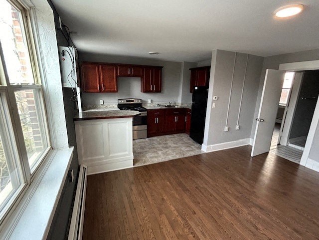 an empty kitchen with wooden floors and white cabinets