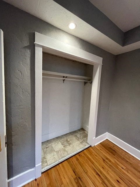 an empty room with a closet and a wood floor
