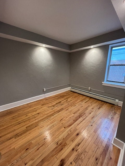 an empty room with wood floors and a window