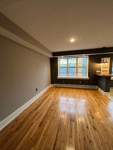 an empty room with wood floors and a window