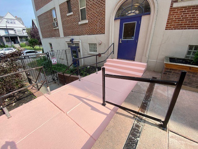 a pink ramp in front of a building with a blue door