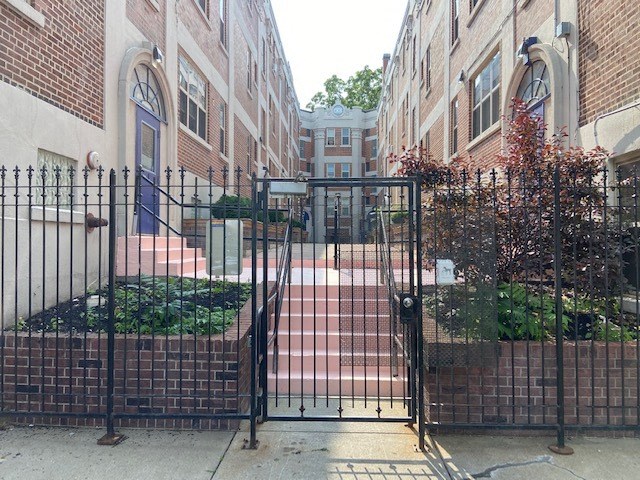 a black gate in front of a brick building