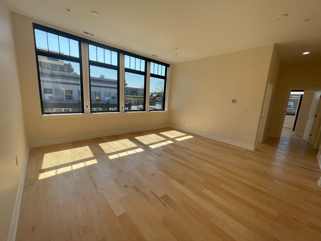 an empty living room with wood floors and windows
